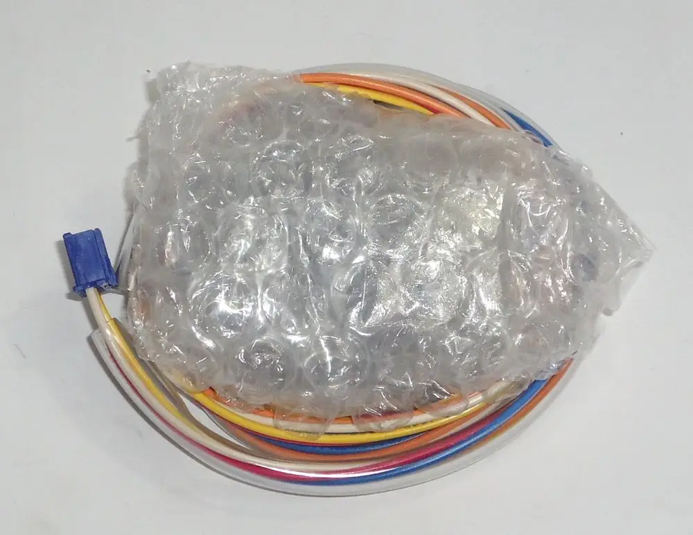 Daikin Elektromagnetventil in plastic schleifen, verpackt in Luftpolsterfolie, umgeben von mehreren farbigen Drähten.